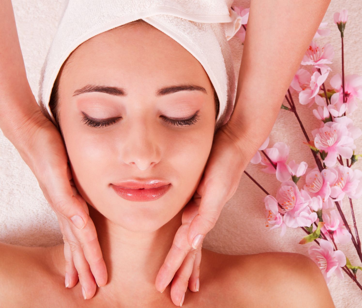 Beautiful Young Woman Getting Massage Facial and Body in Spa Salon. Treatment Cosmetics Beauty Care Body Herbs Surrounded by Flowers